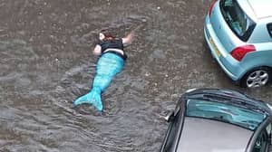 “美人鱼”在洪水泛滥的街道上发现游泳
