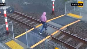 在令人震惊的视频中，一名女子在几英寸内避免被火车撞到