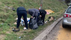 警察让高速公路上的垃圾翻车人清理垃圾