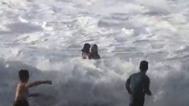 冲浪者拯救溺水的沙滩师在夏威夷退出海