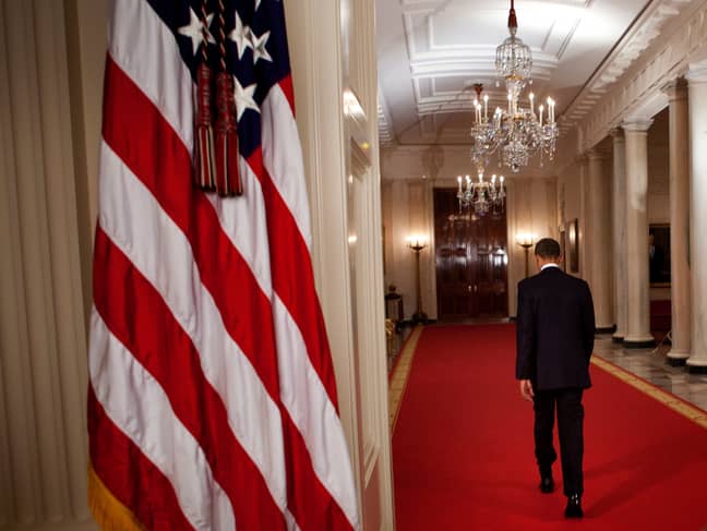 奥巴马总统于2011年5月2日分享新闻后，穿过白宫的十字架大厅。必威杯足球