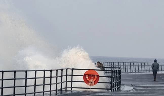 一个男人试图拍照时，波浪溅起了他。信用：肯尼迪新闻和媒体必威杯足球