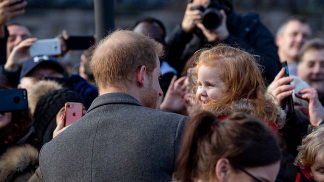 哈利王子拥抱小女孩在Birkenhead。信用：PA
