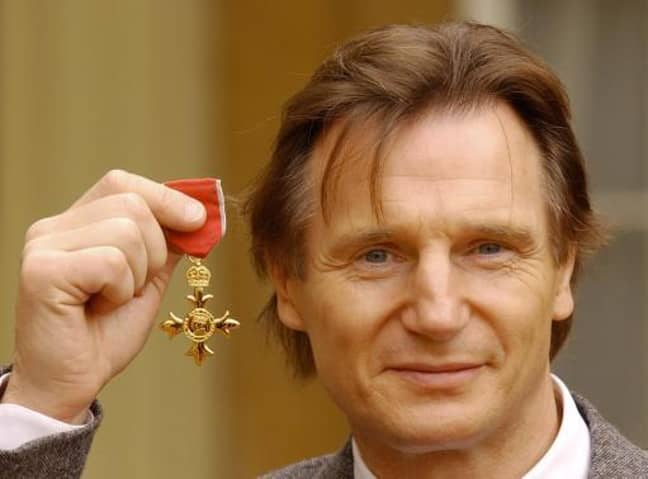 利亚姆·尼森holds his OBE in the forecourt of Buckingham Palace. Credit: PA