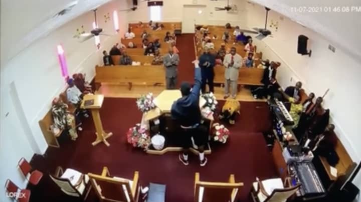 牧师在摄影机上被抓住的教堂里拿下枪手