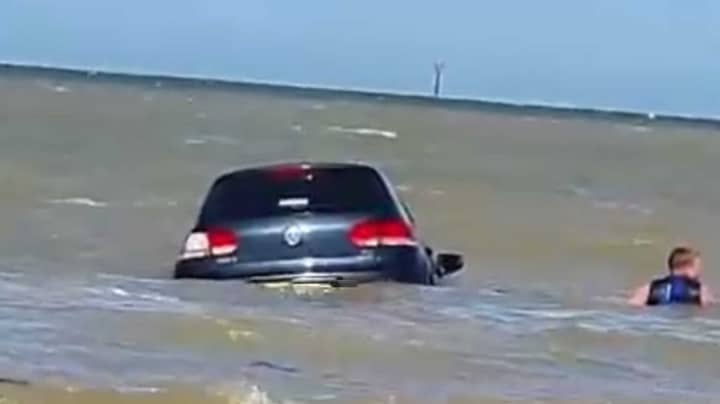 汽车扫入海，促使肯特郡的海滩旅行者进行了巨大的救援行动“width=