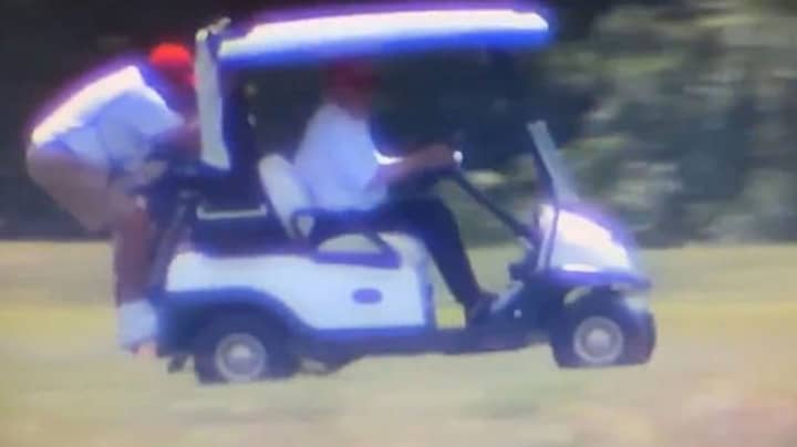 唐纳德·特朗普（Donald Trump）驱动高尔夫球车，球童悬挂在后面