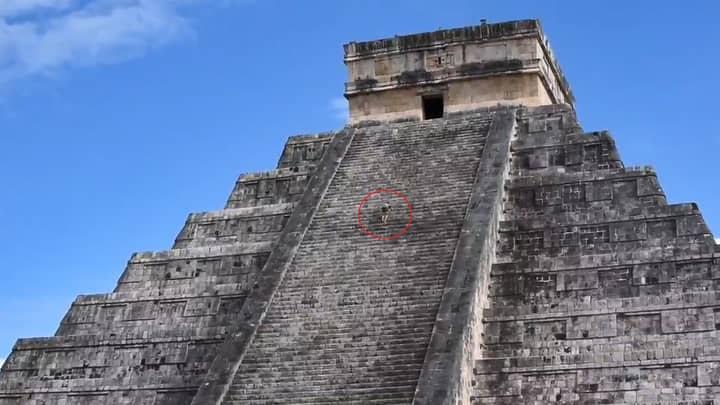 游客拍摄的电影在困惑的人群面前爬上古老的玛雅金字塔