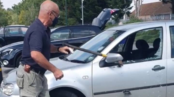 在34摄氏度的热浪中，一名男子用斧头砸碎车窗，拯救了留在车内的狗