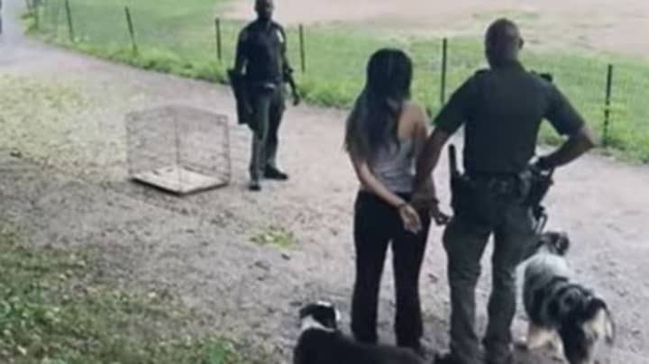 女人戴着手铐并带着牵引的狗walking狗后被带到警察局