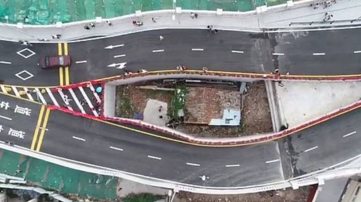 中国城市建造了机器人拒绝移动的小屋周围的高速公路桥