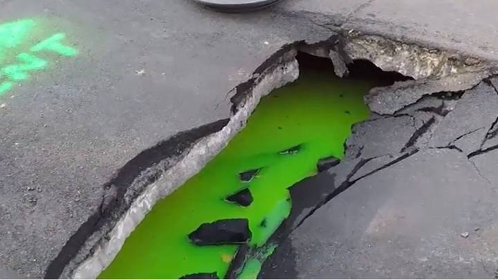 加拿大街一个巨大的地陷渗出明亮的绿色液体