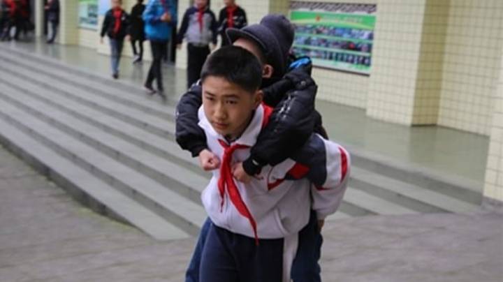 12岁的中国男孩每天都会带他的残疾朋友上学