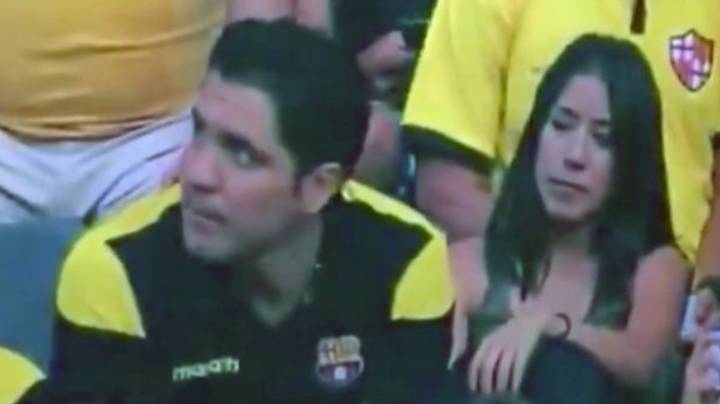 男人对在足球比赛中被抓住在相机上接吻的反应很尴尬
