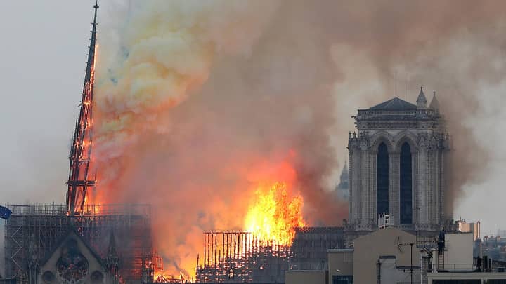 令人心碎的时刻，巴黎圣母院大教堂尖顶倒塌了“width=